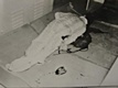 The body of Herb Clutter in the basement of the Clutter home. He had been hanged from an overhead pipe, his throat was slit and he was then shot. After the murder, his body was placed on a mattress on the floor.<BR><BR>A boot print left on the floor beside the body would later be matched to boots owned by Perry Smith.